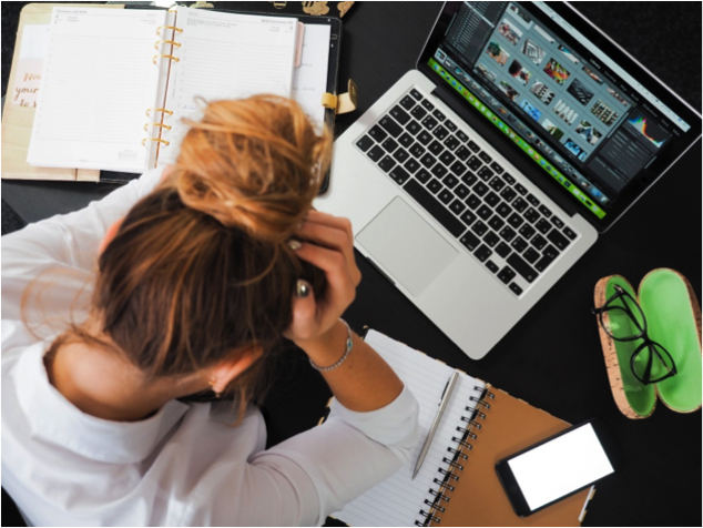 office worker in front of laptop struggling to struggling to create the HSE accident reporting